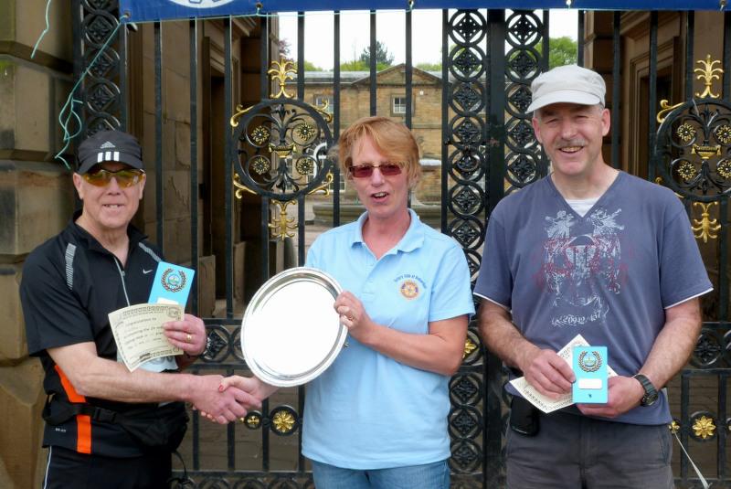 Rotarian Tess Butler presents the Rotary Plate Trophy to Ken Cawthorne. Andrew Winder was the runner (should it be walker!) up.