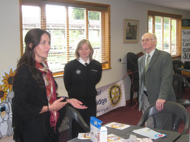 Vicky from OMRON and Lucie from St Johns Ambulance talk with John(Rotary).
