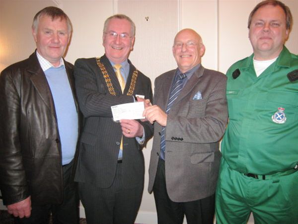 Duns First Responders Iain Lothian and Dave Prentice receive cheque from President Andy in company of David Dickson, SAS Group Coordinator.