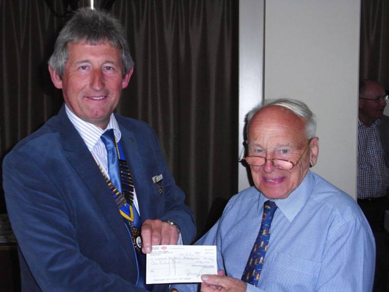 Dr P Carter accepting a cheque from President Nigel.