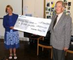David hands the cheque to Mrs Hallam