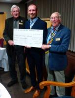 President David Collins receiving the cheque from Jarreth Cush of st James's with Rotarian Dennis Meadus who obtained the donation.