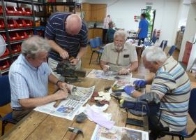 Members of the Rotary Club of Barton-le-Clay help refurbish old tools.