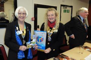 District Governor Carol Reilly Congratulates Eccleshall President Sylvia Keris on the Club's achievements. Rotarian Cllr Brian Price, Deputy Mayor of Stafford in the background