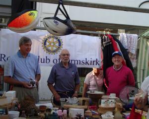 Rotarian Paul Hornak from Ithaca, Michigan, USA with Peter Sewell (President of The Rotary Club of Ormskirk) and (Right) Norman Cunliffe (Chair International) working on a charity stall at Ormskirk Market.