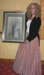 Mair Jones dressed as Mrs. Alethia Eliza Pierce and holding a portrait of Dr. Evan Pierce.