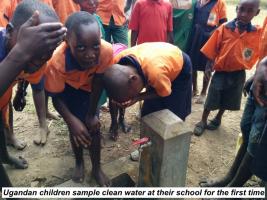 Ugandan children sample clean water in their school for the first time