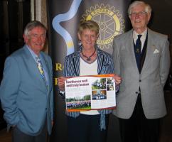 President Iain Smith, Paddy Holmes holding her copy of Rotaryfirst magazine with a 2 page spread on Beat Beethoven and speakers host, David Mackie.