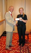President John presents Maisie with Club's cheque for Funding Neuro