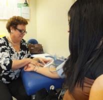 Volunteer Diane Woodward checks the blood pressure of a shopper