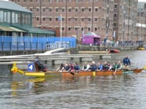 Our team on the water in their dragon boat at Gloucester Docks.