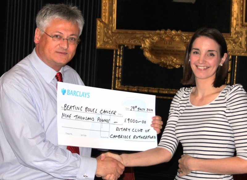 Becca receives cheque from Cambridge Rutherford President. Guy Turvill