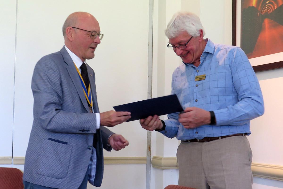 John Davies is presented with a Paul Harris Fellowship by President Ian