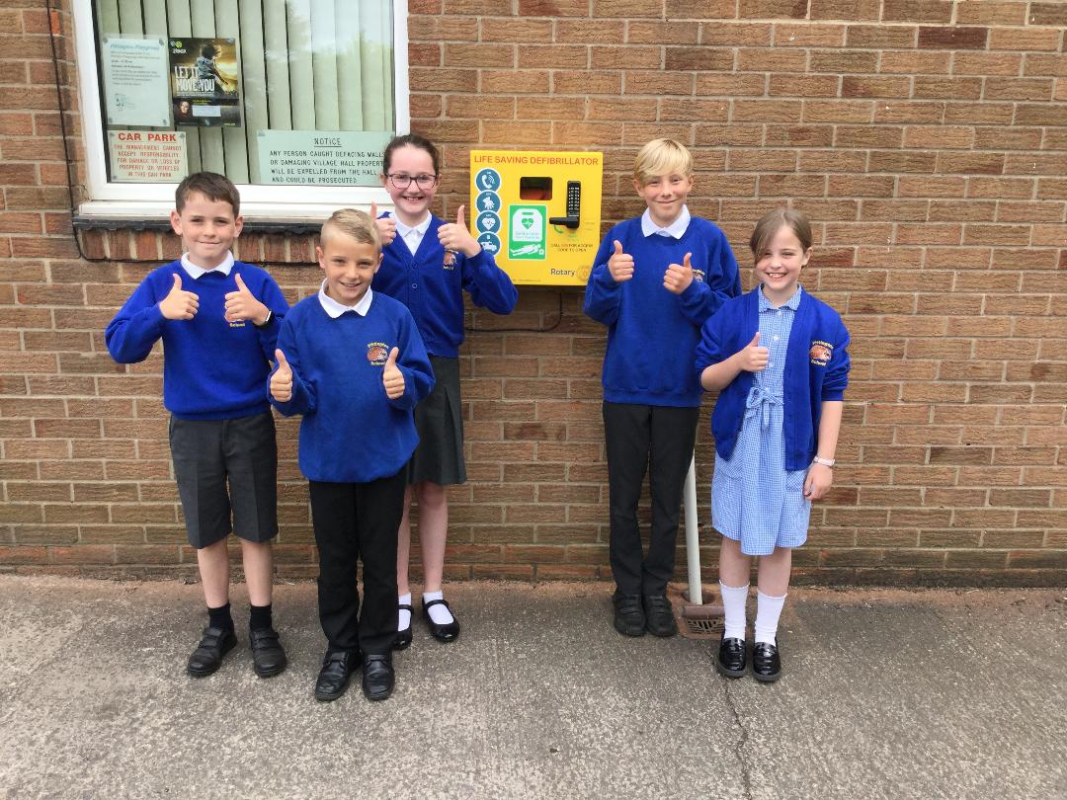 Pupils from Pittington Primary School, next to the Defibrillator that is installed at Pittington Village Hall