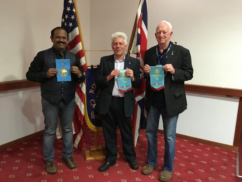 Rotarians Knowles McGill from Sioux Outlook and Balaji Babu from Coimbatore Downtown exchange banners with our own Nigel Wunsch