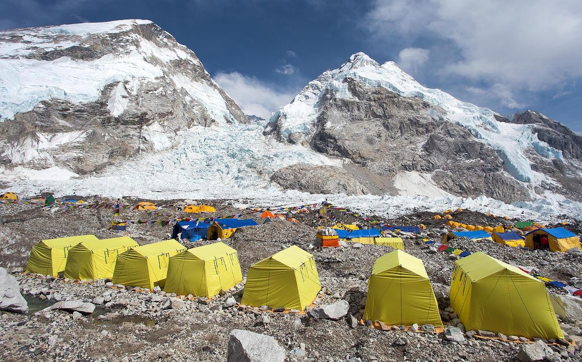 A line of yellow tents among mountains