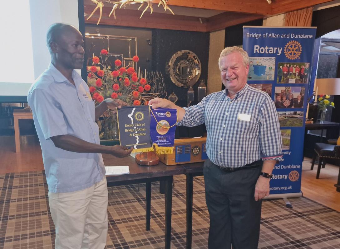 Dr James and President Ivor exchange banners