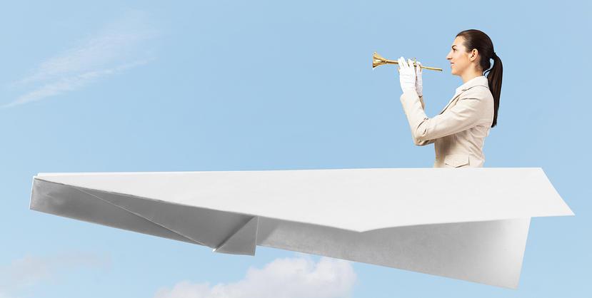 Female trumpeter sitting in a paper aeroplane