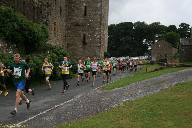 Runners pass Bolton Castle from the Start.