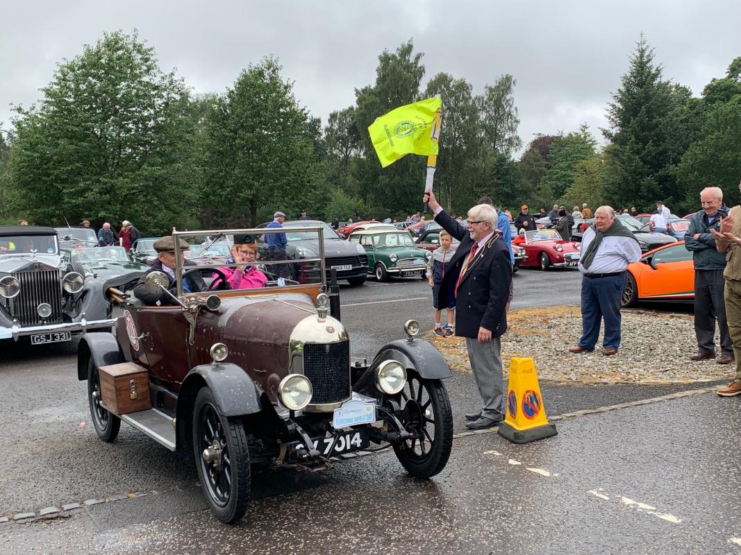 Provost Dennis Melloy flags off the first car.