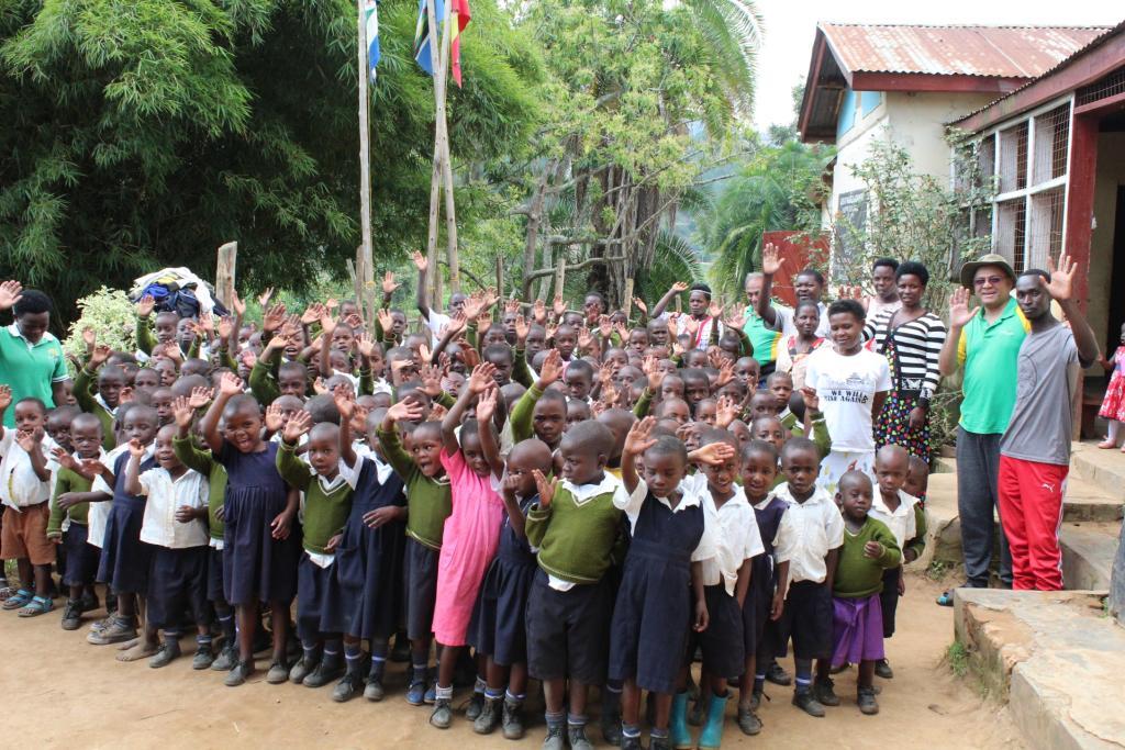 Club member Arun Patel, far right in the green shirt, seen here with happy children living and studying at the Ugandan school and premises co-founded by Arun and his charitable organisation in Kigezi.