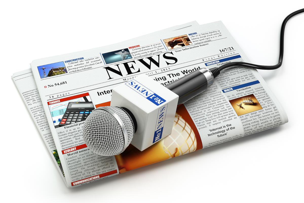 A microphone lying on a news paper.