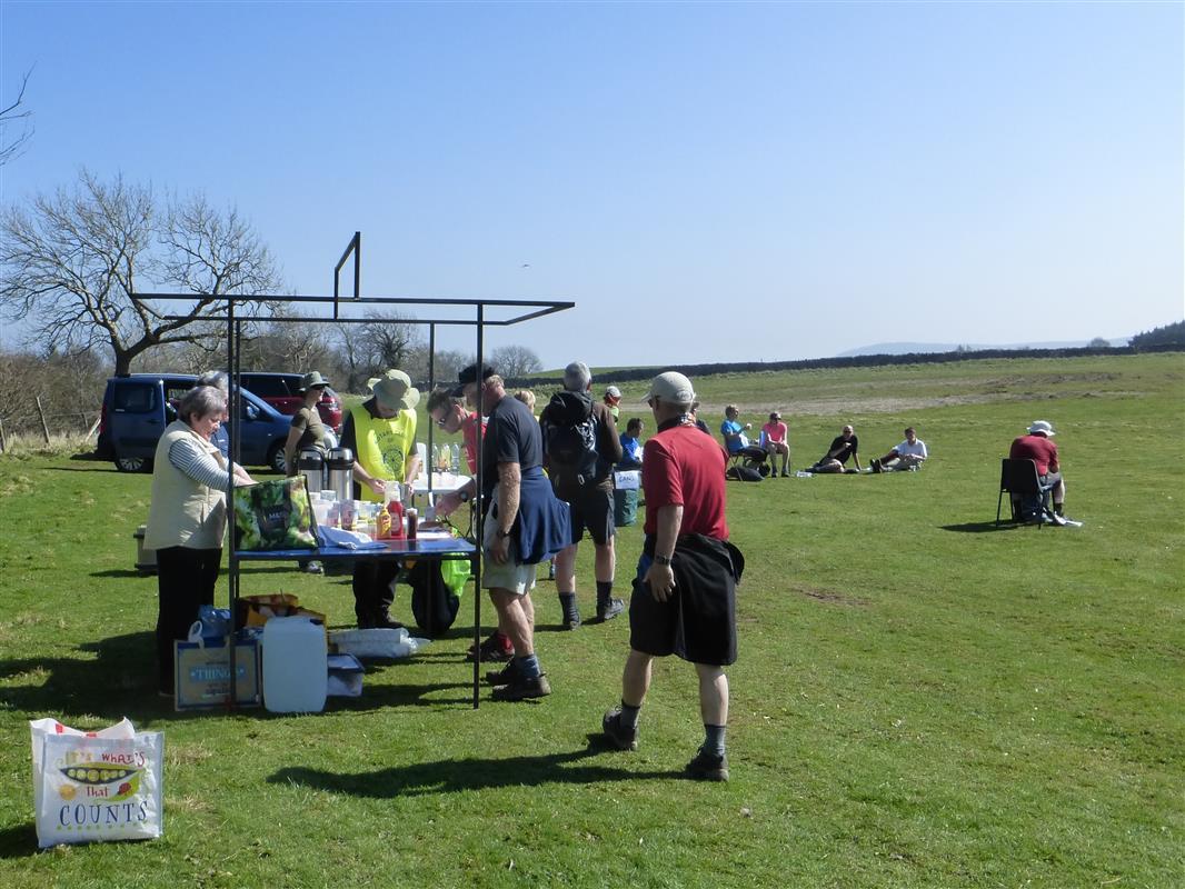 Walkers receiving sausages in bread roll and drinks at halfway on long route