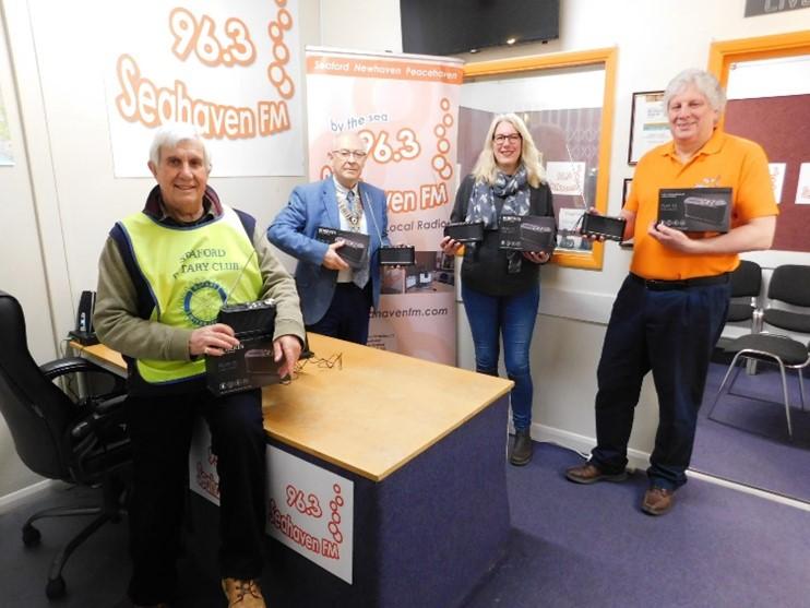 Mary Hawes receives the radios from Rotary President Martin McGill supported by Nick Mallinson MD of Seahaven FM and Rotarian Clive Livingstone