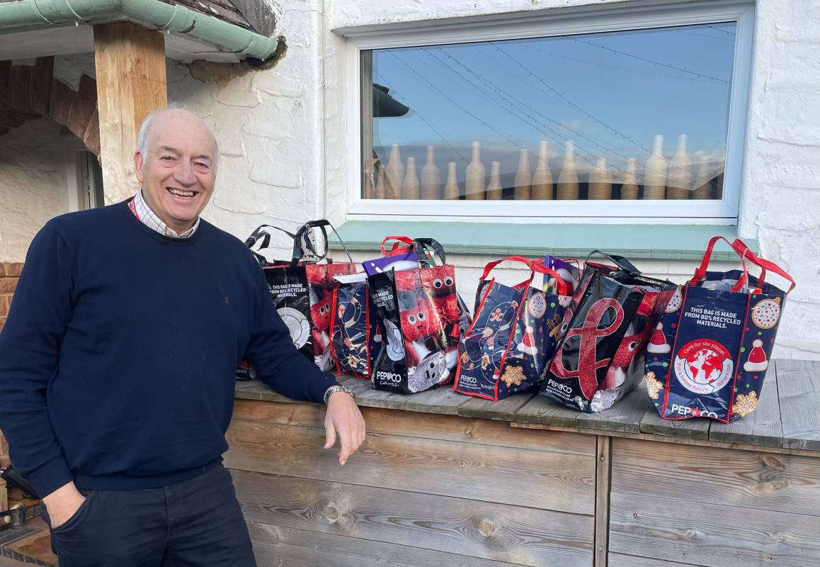 Rotarian Richard Perry and the seven Christmas Food Hampers.