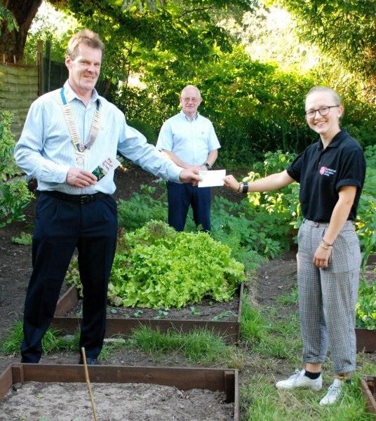 President Chris Ball handing over cheque to one of the young Salvation Army Volunteers