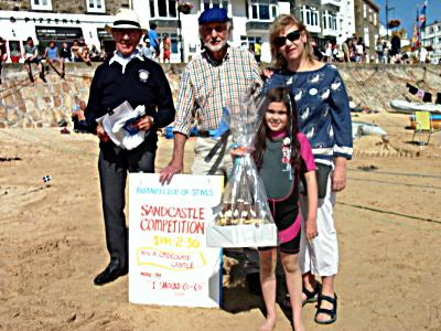 From left to right, Ken Ashmore and Chris  Cocklin of The Rotary Club of St Ives with Andrea Parsons, proprietor of  ' I Should Coco' of St Ives, the competition sponsor with 1st prize winner Daisy Perry.