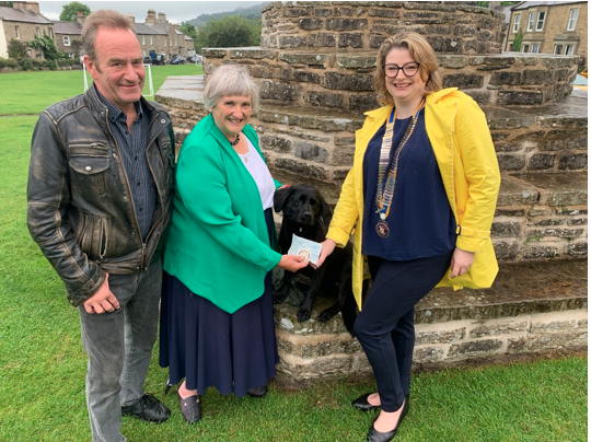 Best Kept Village Competition 2021 - President Emma Fulton presenting a cheque for £400 to Cllr Jane Ritchie MBE, Chairman of Burton-cum-Walden Council, with her dog Katy
and Parish Caretaker Richard Chapman.