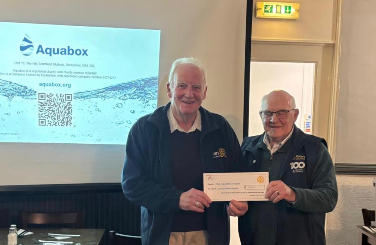 Pictured here is Rotarian Bob Gray (l) presenting a cheque for £300 on behalf of the club to John, in support of the ongoing Aquabox project work.