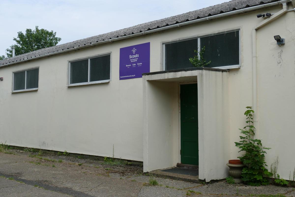 A white industrial building with a notice bearing the Scout logo