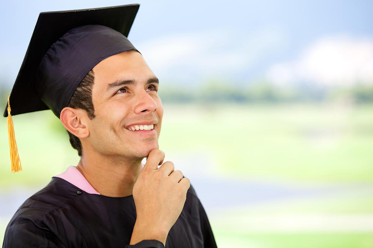 A young male teacher in mortar board and gown