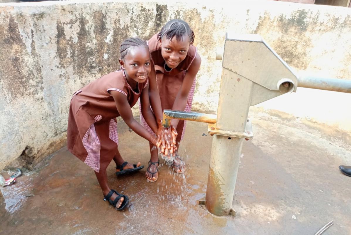 girls using the new well at Banbury International Community School