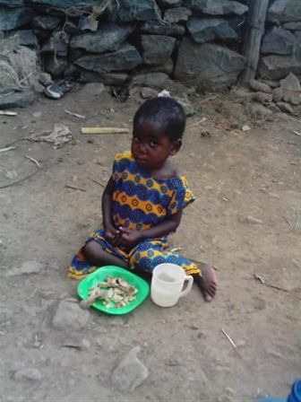 A little Girl eats her lunch sat in the dust lake shore Kisumu our visit 2007