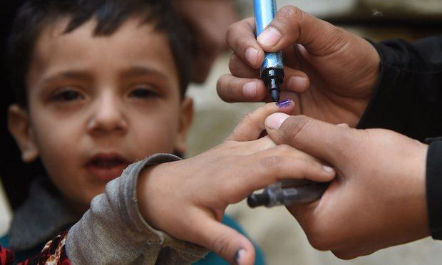  A Pakistani health worker marks a child