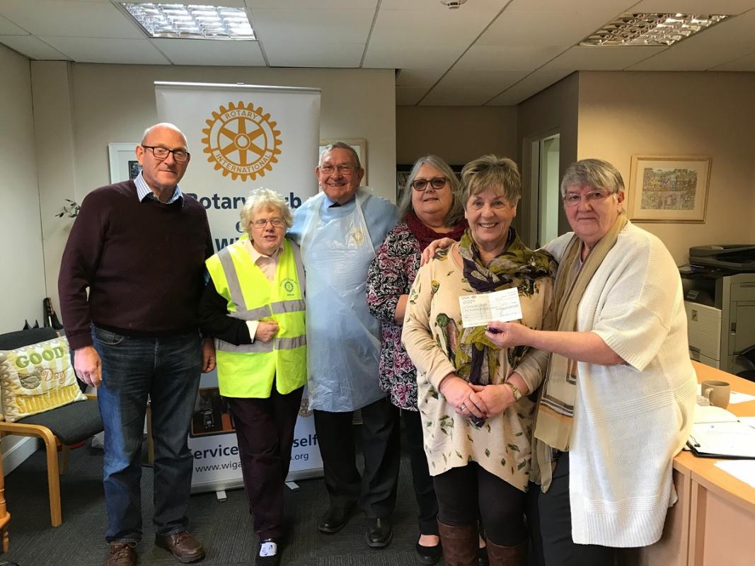 Picture of Barbara Nettleton receiving a cheque from Wigan Rotary Club. 