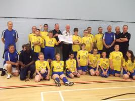 Bexhill President Mike Barton (in white shirt) holding the cheque with Chairman Barry Elphick + Oliver Moon (left) with Harold Lawrence and the 70th birthday card