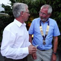 Outgoing Club President Clive Littleton hands over to incoming Club President Graham Holland