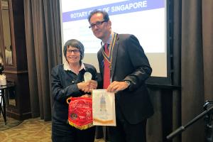 Our member, Anne MacKinnon, exchanging club pennants with the president of the Singapore Rotary Club 