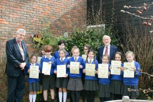 Entrants from Busbridge Junior School having been presented with their certificates., The winner, Sophie, is fourth from the left in the front row. Also pictured from Woolsack are President Simon Crowther (left) and Tim Kendall, event organiser.