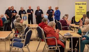 Brit Valley Rotarian Ian Ibbotson introduces the visiting sea shanty group to Bridport Blind Club.