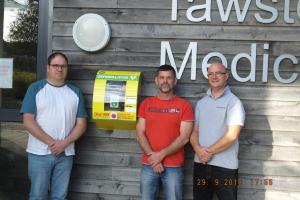 Club President Mike Trott hands over a defibrillator to Tawstock Medical Centre.