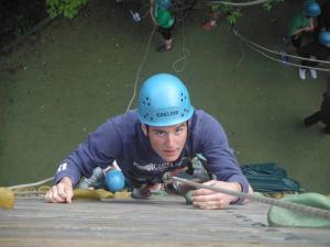 Tom climbing up the vertical wall towards the camera.