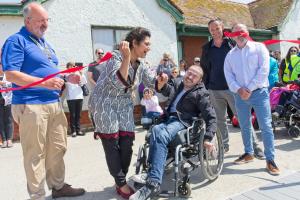 Sam Taylor with Mayor Cllr Nazish Adil cuts the ribbon to open Seaford Beach access with Rotarian Rodney Reed looking on.