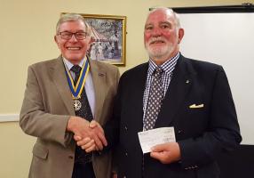 President Steve Knight presents Mike McConville with a cheque in support of the Farmers Overseas Action Group