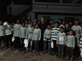 Idu Miah with the Rampur High School team in Bangladesh wearing kit donated by Dukinfield Youth and Junior Football Club