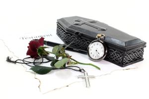 Model coffin, with a pocket watch and a single rose.